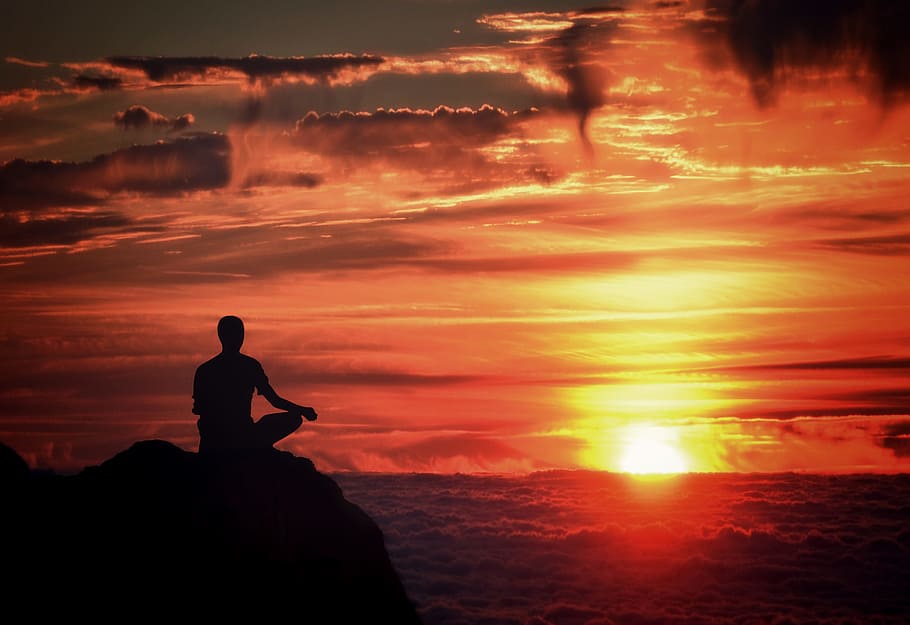 man meditating on mountaintop