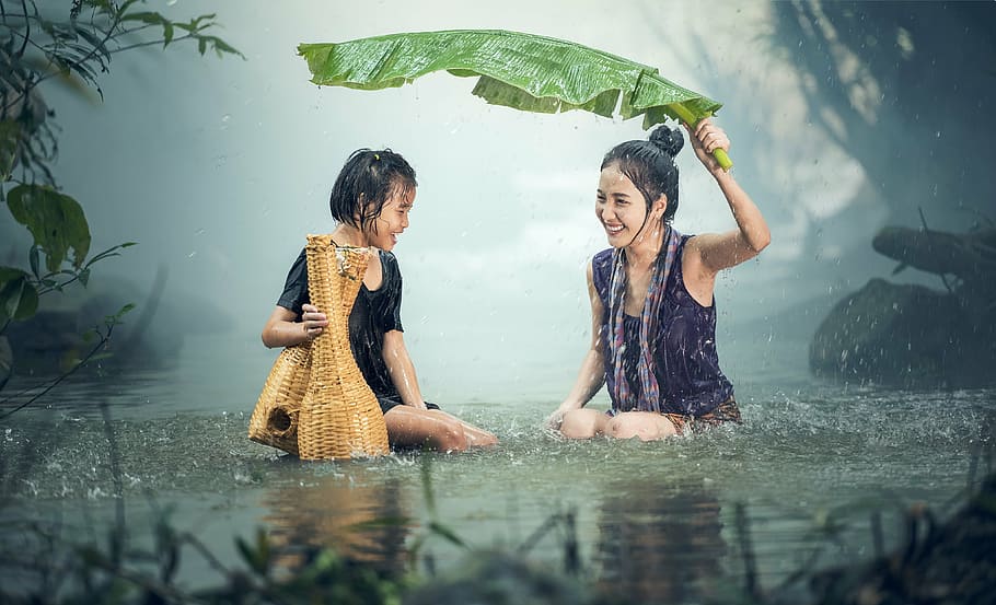 two females laughing in rain